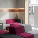 Collaborative Office Furniture - Professional 16:9 hero banner. Ultra high resolution. An architectural detail of a modern, inviting office space, focusing on a versatile modular seating arrangement in shades of grey and deep magenta (#E2087E). The area is bathed in a soft, strategic accent glow of #737373, highlighting the adaptable design and integrated technology ports subtly. A mobile whiteboard with faint, overlaid conceptual diagrams stands nearby, indicating dynamic teamwork. The setting reflects a prestigious, yet practical UK office environment, embodying Cost Cutters UK's expertise in creating functional, collaborative zones. Style: Editorial photography with a focus on clean lines and sophisticated design. Avoid: Groups around holographic tables, generic tech aesthetics, text overlays, cold blue tones, stock photo clichés.