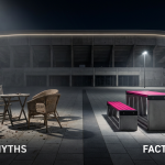 Myths vs. Facts - Professional 16:9 hero banner. Ultra high resolution. A visually compelling scene where a football stadium's exterior, subtly illuminated by a #737373 accent glow, meets a robust, contract-grade outdoor picnic table and chairs. One side of the image depicts crumbling, domestic-style garden furniture casting a shadow, representing 'myths', while the other side showcases sleek, modern, and sturdy commercial outdoor furniture, brightly lit with #E2087E and #000000 accents, representing 'facts'. The composition uses a clear visual divide to emphasise the contrast between flimsy and durable. Style: Editorial photography with dramatic, contrasting lighting. Avoid: Groups around holographic tables, generic tech aesthetics, text overlays, cold blue tones, stock photo clichés.