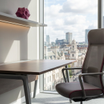 Avoiding Maintenance Mistakes - Professional 16:9 hero banner. Ultra high resolution. A meticulously maintained, sleek architectural detail of a modern, well-lit university library or corporate office interior in the UK. Focus on a pristine, ergonomic desk and chair set (commercial furniture), with a subtle, glowing accent light in #737373 illuminating the clean lines and robust materials. The background features a blurred, expansive window view of a calm, organised cityscape, representing foresight and strategic planning. Elements of #E2087E subtly integrated into the furniture design or decorative accents. The overall mood is one of quiet efficiency and enduring quality. Style: Architectural photography with a focus on clean lines and modern design. Avoid: Groups around holographic tables, generic tech aesthetics, text overlays, cold blue tones, stock photo clichés.