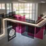 School Furniture Pitfalls - Professional 16:9 hero banner. Ultra high resolution. A visually striking abstract geometric composition symbolising 'pitfalls' and 'solutions' in school furniture projects. Imagine a series of brightly coloured, interconnected 3D blocks and pathways, some leading to dead ends (pitfalls) and others forming clear, illuminated routes (solutions). The 'solution' paths are highlighted with a glowing #737373 light, while the 'pitfall' areas are subtly shadowed but also contain elements of #E2087E and #000000. The setting is a clean, conceptual educational environment, suggesting strategic planning. Style: Architectural photography with a focus on clean lines and dynamic perspective. Avoid: Groups around holographic tables, generic tech aesthetics, text overlays, cold blue tones, stock photo clichés.